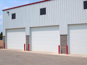 A set of three commercial garage doors shown from the exterior of a building